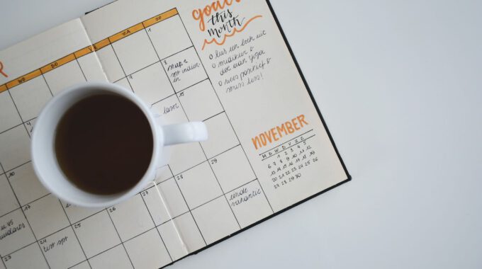 Aufgeschlagener Kalender und Kaffee
