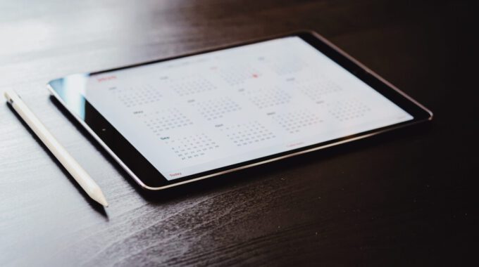 Tablet mit geöffneter Kalender-App auf einem Holztisch