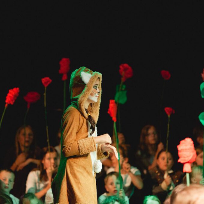 Der Fuchs in der Kinderoper "Der kleine Prinz", im Hintergrund viele Rosen