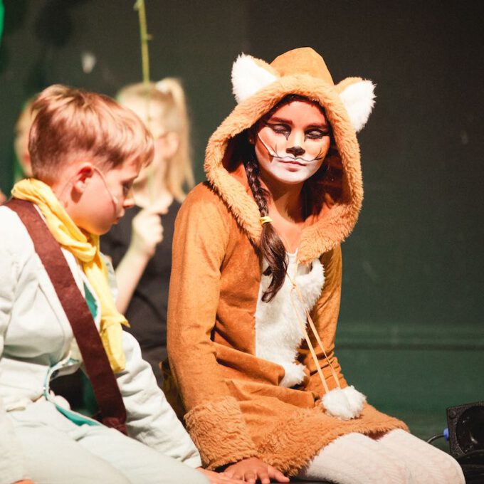 "Der kleine Prinz" sitzt mit dem Fuchs am Bühnenrand.