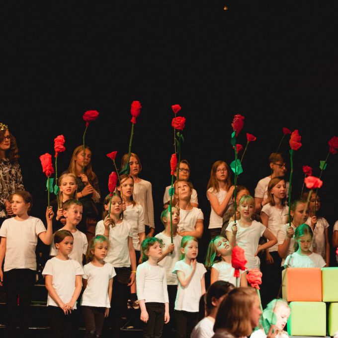 Mitglieder des Kinderchores halten selbstgebastelte Rosen in den Händen