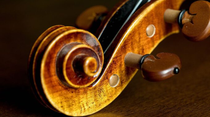 Kopf einer Violine auf hölzernem Grund