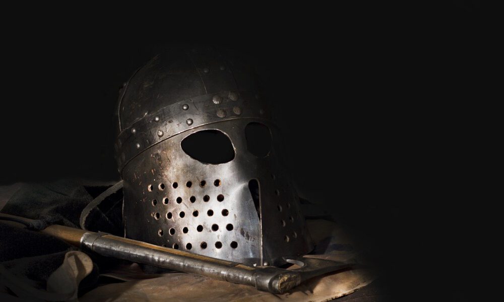 Wikingerhelm und -schwert vor dunklem Hintergrund