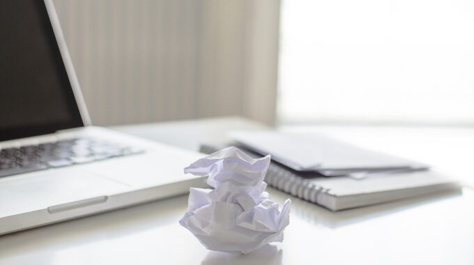 Schreibtisch mit zerknülltem Blatt Papier